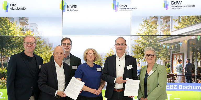 (v.li.) Hendrik Bollmann (MdB, SPD), Alexander Rychter (Verbandsdirektor des VdW RW), Prof. Dr. Torsten Bölting (InWIS-Geschäftsführer), Almuth Draeger (BMWSB), Dr. Christian Lieberknecht (GdW-Vorstand) und Sylvia Rietenberg (MdB, Bündnis 90/DIE GRÜNEN) verabschieden den „Bochumer Impuls 2026“. Bildquelle: EBZ/Andreas Molatta.