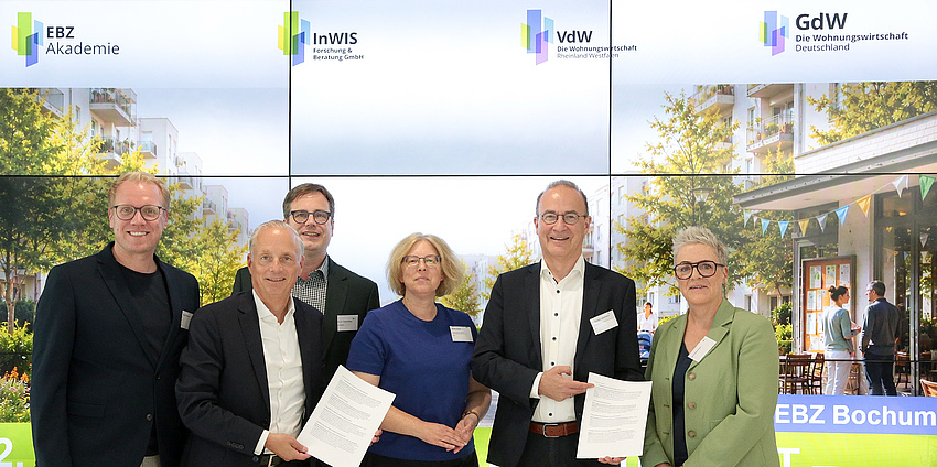 (v.li.) Hendrik Bollmann (MdB, SPD), Alexander Rychter (Verbandsdirektor des VdW RW), Prof. Dr. Torsten Bölting (InWIS-Geschäftsführer), Almuth Draeger (BMWSB), Dr. Christian Lieberknecht (GdW-Vorstand) und Sylvia Rietenberg (MdB, Bündnis 90/DIE GRÜNEN) verabschieden den „Bochumer Impuls 2026“. Bildquelle: EBZ/Andreas Molatta.