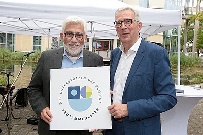 #ZUSAMMENLEBEN: Bochums Oberbürgermeister Jörg Lukat (li.) unterstützt gemeinsam mit EBZ-Vorstand Klaus Leuchtmann das Förderprojekt für das Forschungsinstitut InWIS. Bildquelle: EBZ/Andreas Molatta.